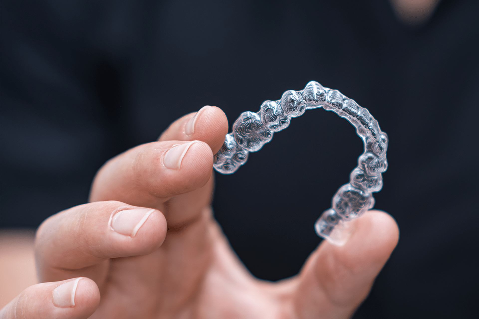 A dentist showcases invisible aligners to a patient, highlighting their benefits for a discreet orthodontic treatment