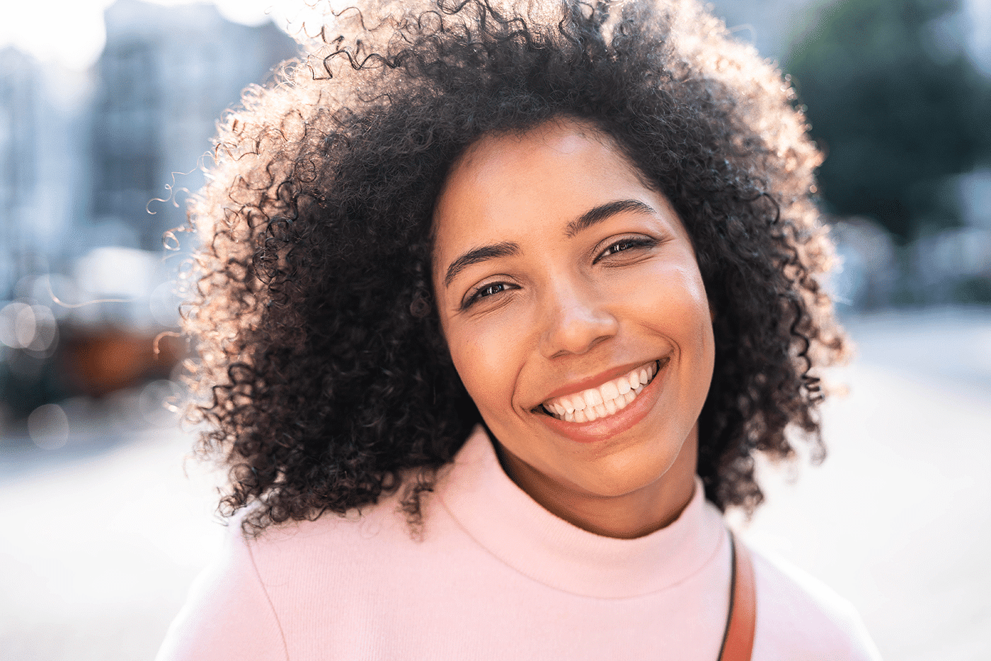 A woman beams with joy, showcasing her bright smile and radiant happiness